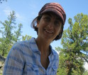 Scientist Amy Hessl holding a cross-section of wood from a preserved log.